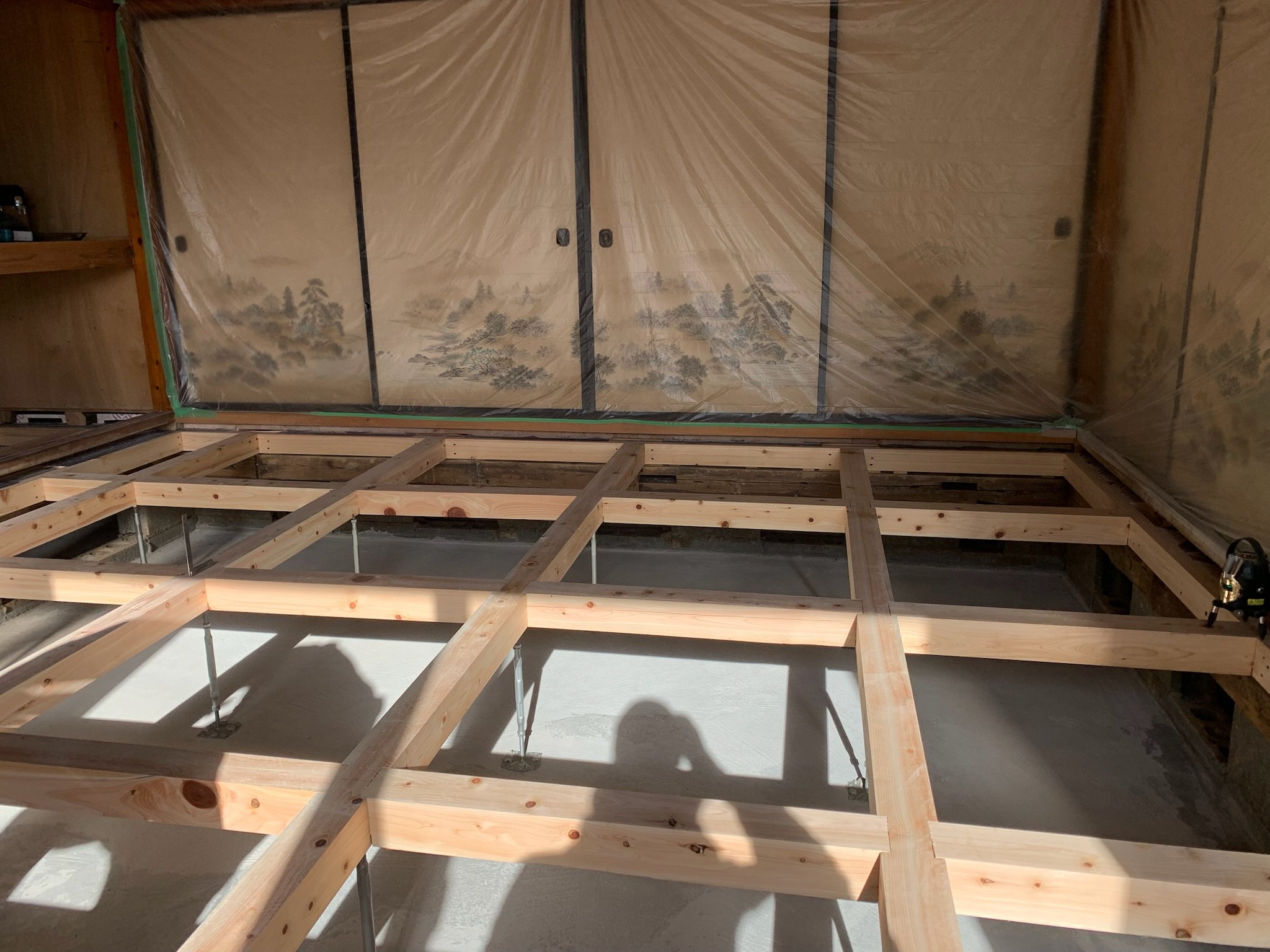 既存の建具を養生しながら床下地を組み直している住宅改修の途中